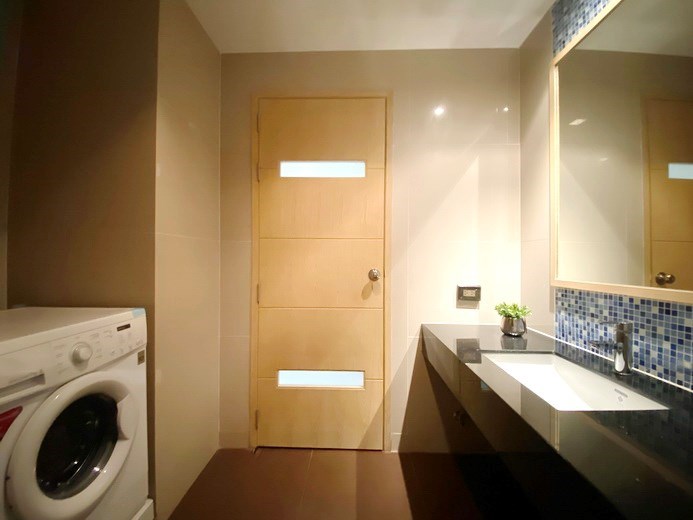 Condominium for sale Na Jomtien showing the bathroom with washing machine 