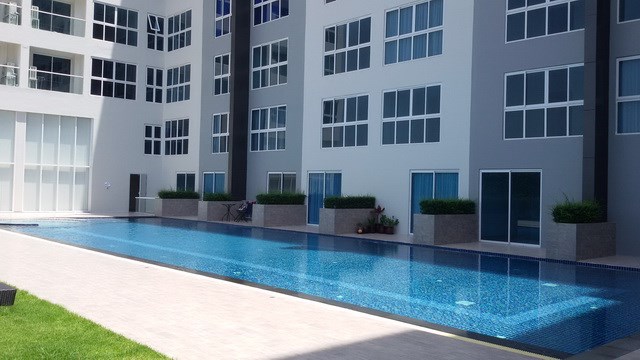Condominium For Rent Pattaya showing the communal swimming pool and building 